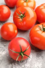 Fresh ripe tomatoes on grey textured table, closeup