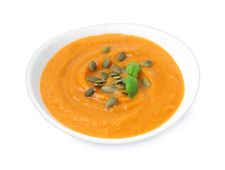 Delicious pumpkin soup with seeds and basil in bowl isolated on white