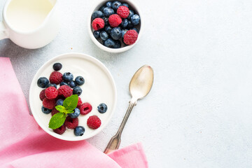 Yogurt with fresh berries in white bowl.