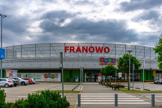 Entrance to Franowo shopping center in Poznań with visible Smyk store and parking area in front