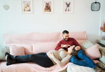 Expecting couple relaxing on sofa feeling pregnant happiness