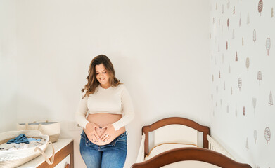 Pregnant woman making heart shape on belly