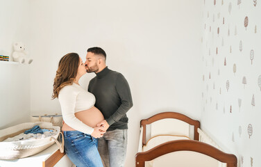 Expecting couple kissing, celebrating future family
