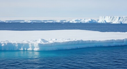 Expansive Antarctic Landscape Blue Ocean and Massive Ice Floe Under Clear Sky Featuring Distant Glaciers and Iceberg Formations