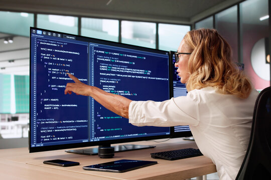 Young Female Coder Writing Code On Computer Screen