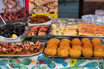 Delicious fresh cooked street food on daily food market in Palermo, Sicily, travel destination, food tourism Italy, variety of roasted, grilled fish, seafood, meat, vegetables served snacks, dish