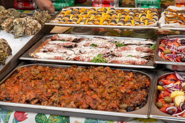 Delicious fresh cooked street food on daily food market in Palermo, Sicily, travel destination, food tourism Italy, variety of roasted, grilled fish, seafood, meat, vegetables served snacks, dish