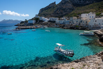 Fototapeta premium Levanzo, smallest of Egadi Islands, tranquil retreat near Sicily, picturesque village around harbor, white houses and charming blue-water harbor, travel destination, boat trip