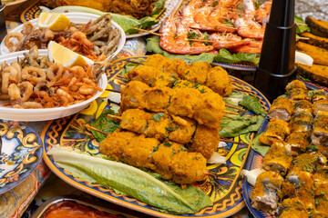 Delicious fresh cooked street food on daily food market in Palermo, Sicily, travel destination, food tourism Italy, variety of roasted, grilled fish, seafood, meat, vegetables served snacks, dish