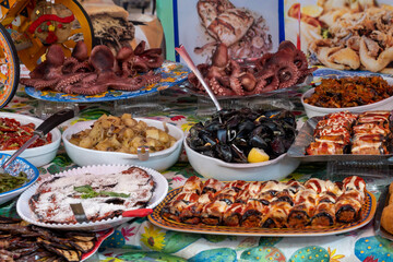 Delicious fresh cooked street food on daily food market in Palermo, Sicily, travel destination, food tourism Italy, variety of roasted, grilled fish, seafood, meat, vegetables served snacks, dish