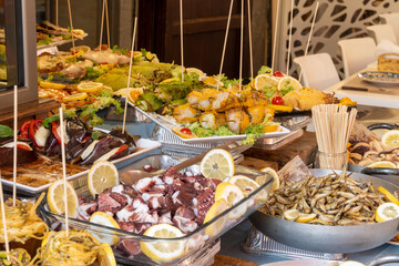 Delicious fresh cooked street food on daily food market in Palermo, Sicily, travel destination, food tourism Italy, variety of roasted, grilled fish, seafood, meat, vegetables served snacks, dish