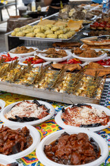 Delicious fresh cooked street food on daily food market in Palermo, Sicily, travel destination, food tourism Italy, variety of raw, roasted, grilled fish, seafood, meat, vegetables snacks or dshes