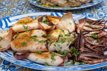 Delicious fresh cooked street food on daily food market in Palermo, Sicily, travel destination, food tourism Italy, variety of roasted, grilled fish, seafood, meat, vegetables served snacks, dish