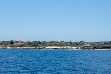 Fototapeta premium Coastline of Favignana island with tuff rocks, cultural heritage abandoned quarries, caves, ancient extraction of calcarenite, stone used for building, Egadi Islands near Sicily, Italy