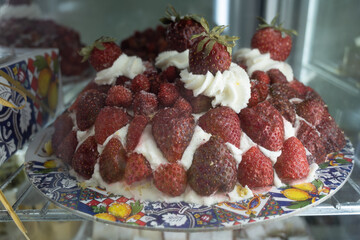 Sicilian desserts, sweets, cakes with ricotta cream, fruits, pistachio, on display in confectionery artisan shop