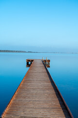 Fototapeta premium Morning stillness and mirror-quiet water at Stagnone of Marsala, lagoon and nature reserve near Marsala, Sicily, Italy, fisherman's boats