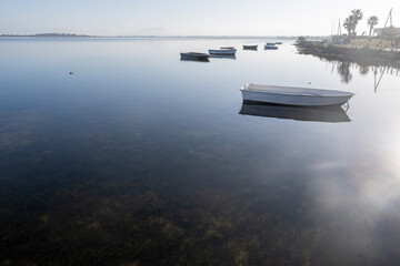 Morning stillness and mirror-quiet water at Stagnone of Marsala, lagoon and nature reserve near Marsala, Sicily, Italy, fisherman's boats
