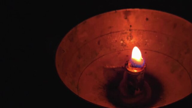 A lit diya, a traditional oil lamp from the Indian subcontinent, is used in religious ceremonies and festivals like Diwali. It symbolizes the victory of light over darkness and good over evil.