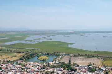 Panoramic landscape of Jamay, Jalisco, featuring Xamain Island, the lake, and lush green surroundings under clear skies
