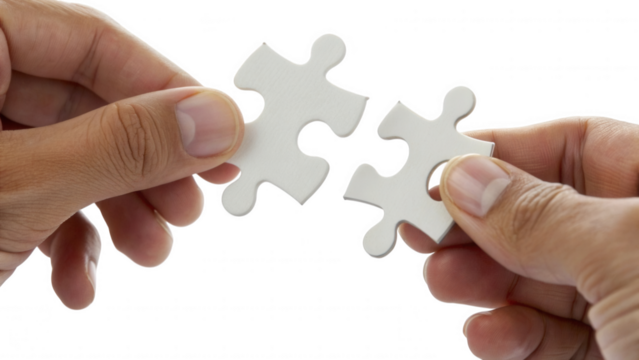 Hands connecting two white puzzle pieces together against a black background