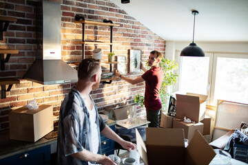 Male couple unpacking in new home