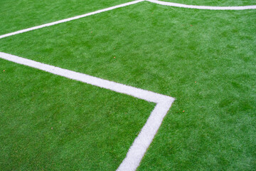 Obraz premium green artificial grass turf with white line for sports field background texture