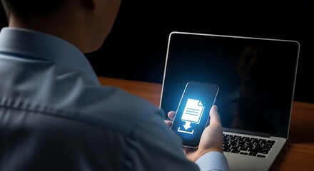 Man using smartphone for file download and laptop work concept