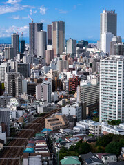 Fototapeta premium Aerial view of central Tokyo with rail tracks and distant bay