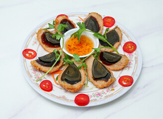 Indulge in these exquisitely prepared fried century egg canapés, a unique fusion of textures and flavors. Garnished with fresh herbs and tomatoes, served with a tangy dipping sauce.
