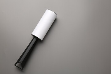 Lint roller on grey background, top view. Space for text