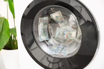 Money laundering. Many dollar banknotes in washing machine indoors, closeup