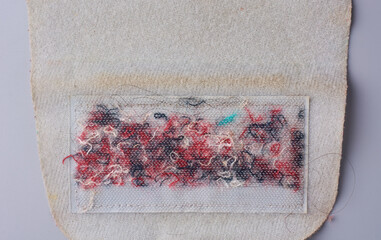 close-up of worn velcro or hook-and-loop fastener contaminated with tangled threads and debris, showing wear and discoloration on an old medical cuff, concepts of hygiene and wear and tear