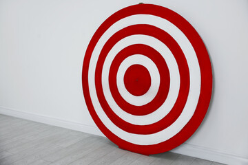 Round shooting target on floor near white wall