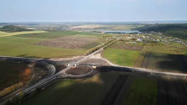Highway interchange under construction connecting rural countryside. Clip