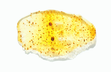 Close-up of exfoliating gel with orange granules on white background.