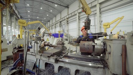 Factory worker operating lathe machine in manufacturing plant. Stock clip