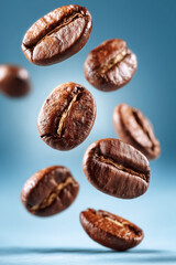 Floating roasted coffee beans on blue background