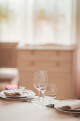 Elegant dining setup with sparkling glassware, fine plates, and soft lighting in a cozy restaurant setting