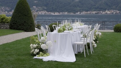 An Elegant Outdoor Dining Setup Featuring a Scenic Lake View Perfect for Any Occasion. Action