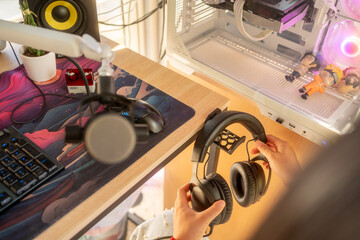 Person holding headphones ready for gaming or podcasting at home © Jorge