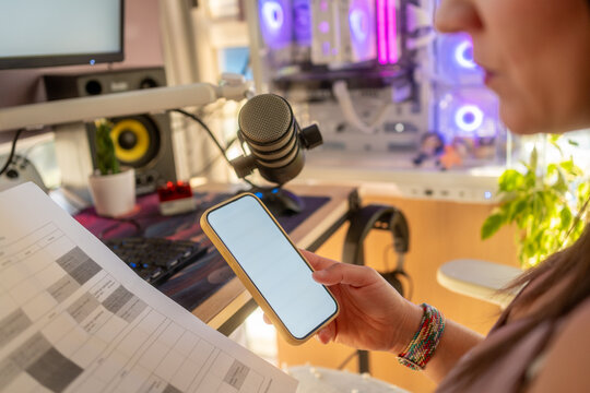 Woman planning podcast content using smartphone at home office - Powered by Adobe