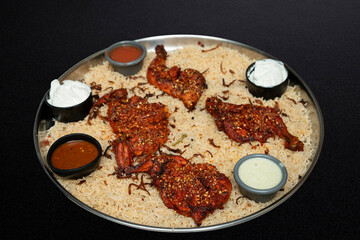 Arabian chicken Manthi or mandi cooked meat, Basmati rice with Masala, spice. Kuzhimanthi or hot and spicy Manthi on black background in South India. Top view of Indian non veg food