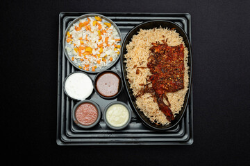 Arabian chicken Manthi or mandi cooked meat, Basmati rice with Masala, spice. Kuzhimanthi or hot and spicy Manthi on black background in South India. Top view of Indian non veg food