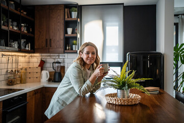 Woman enjoying morning coffee in modern kitchen