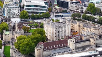 Cinematic aerial view of the historic Tower of London its iconic historic fortress, surrounded by the River Thames, Tower Bridge, and the modern skyscrapers of the City of London - Powered by Adobe