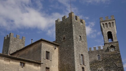 Castell'arquato fortress and clock tower under blue sky. Action
