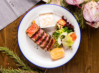 exquisite seared tuna steak chunks, complemented by a refreshing salad and luscious sauce. Ideal for showcasing culinary excellence and healthy gourmet options.