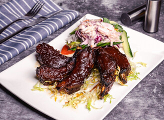 Perfectly mini barbecued ribs paired with crisp salad. Ideal for food blogs or restaurant promos, showcasing culinary delight and delicious flavors. Tempting and tasty!
