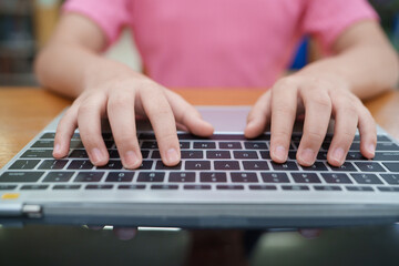 Hands typing on a laptop keyboard, close-up.