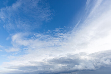 Fototapeta premium A expansive blue sky filled with fluffy white clouds, natural background photo